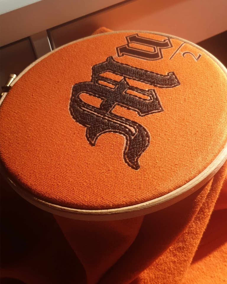Close up of the embroidery process for the mutiara piece showing the letter M